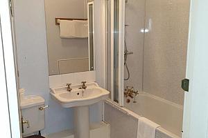 En-suite bathroom with bath and shower over